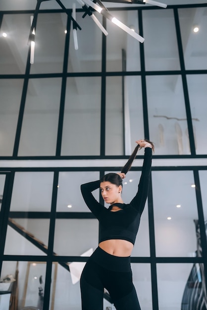 Foto de una adorable jovencita vestida con traje deportivo sonriendo en casa