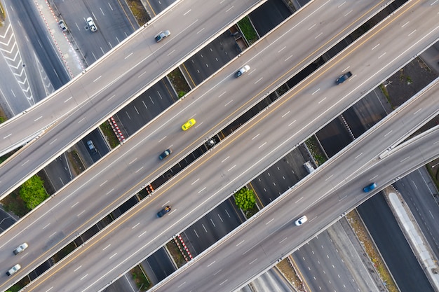Foto aérea de la carretera de cruce de carreteras elevadas multinivel que pasa por la ciudad moderna en múltiples direcciones