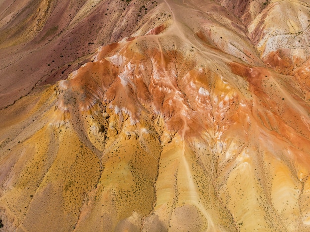 Foto aérea das montanhas com textura amarela e vermelha semelhante à superfície de marte
