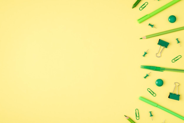 Foto aérea de caneta e lápis verde marcador de papelaria isolado no fundo amarelo com espaço vazio