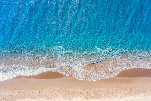 Foto aérea de drone vista superior da praia de perissa com belas ondas de água e mar turquesa fundo de viagem de férias mar egeu ilha de santorini grécia