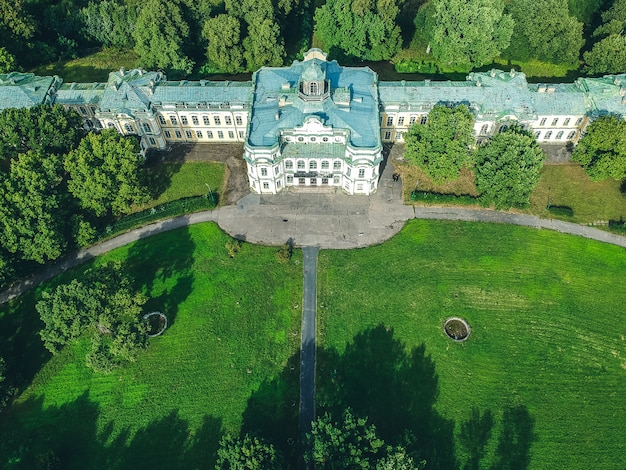 Foto aérea de um palácio abandonado na floresta. gramado verde, árvores, dia de verão. rússia, são petersburgo, peterhof. postura plana.