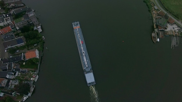 Foto aérea de uma barcaça navegando pelo rio na cidade