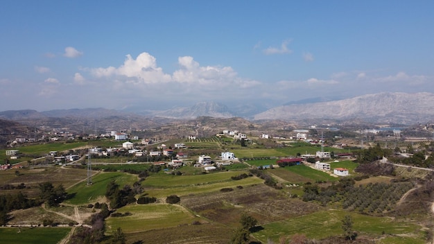Foto foto aérea de uma vila no interior da turquia mostrando terras agrícolas e montanhas atrás dela