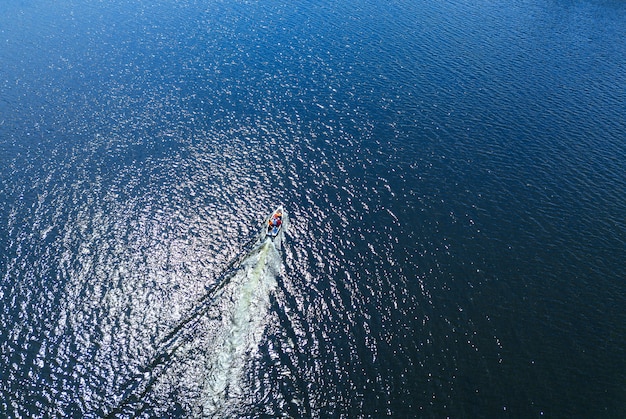 Foto aérea do barco que flutua no mar ou oceano com água azul durante o verão, conceito de férias.