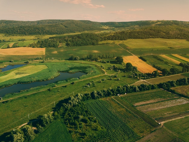 Foto aérea de drone con hermoso paisaje farmlamnd al atardecer en atmósfera rural