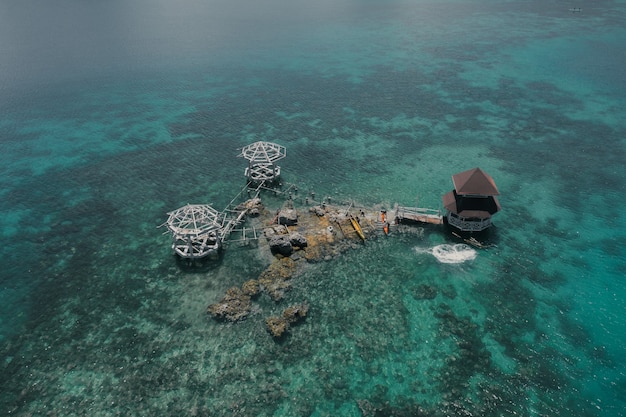Foto aérea incrível de uma casa de campo luxuosa no meio da água do oceano azul