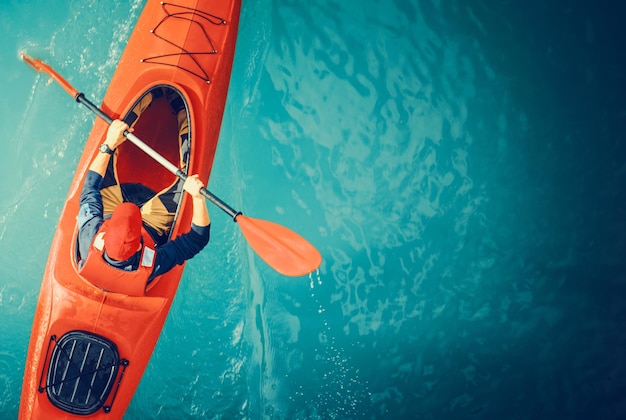 Foto foto aérea de kayaker lake tour kayak rojo y deportista de remo caucásico de unos 30 años