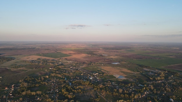 Foto aérea de la parte superior de un dron volador de una tierra con campos en el campo.