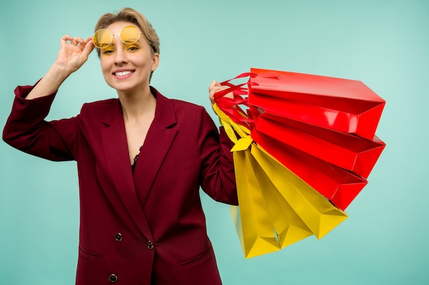 Foto de agradable chica encantadora atractiva chica alegre que acaba de terminar de compras y estar muy contento y alegre mientras con azul