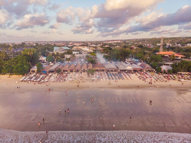 Foto desde el aire, desde el dron Playa balinesa de Jimbaran famosa por sus perfectos restaurantes de comida de mar.