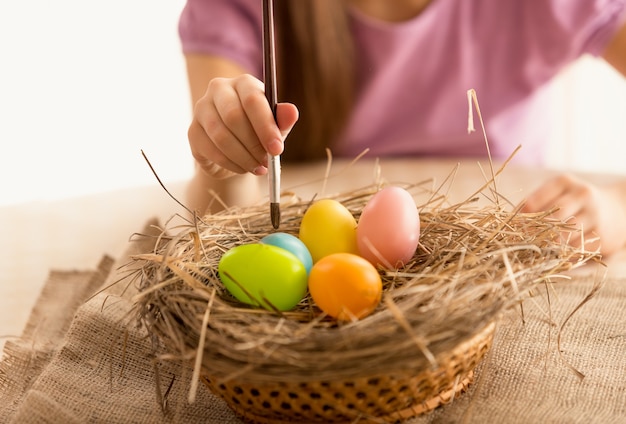 Foto aislada de niña pintando huevos de Pascua