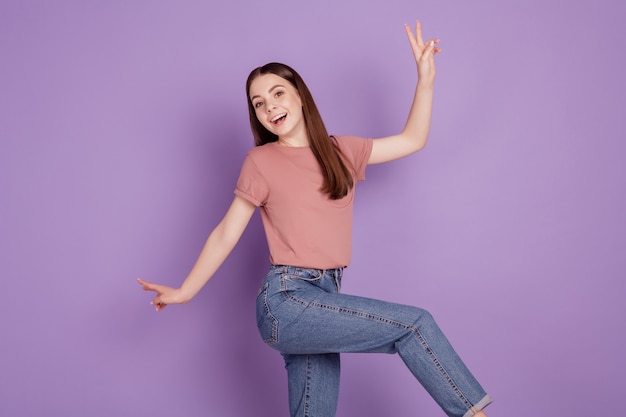 Foto de alegre chica despreocupada bailando aislado sobre fondo violeta