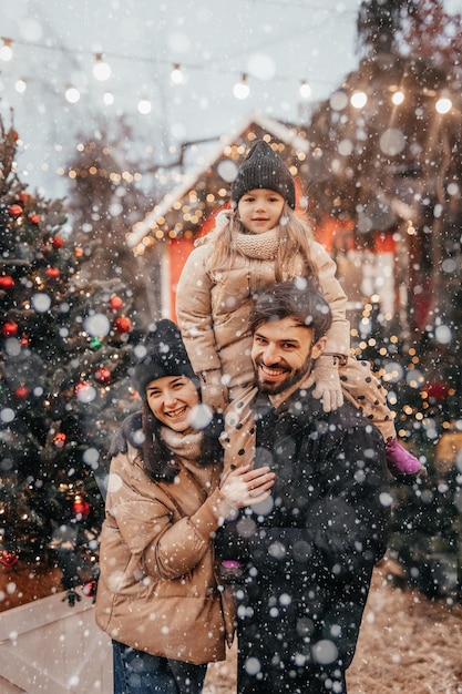 Foto de la alegre familia con su hija a cuestas feliz sonrisa positiva mirarse el uno al otro invierno