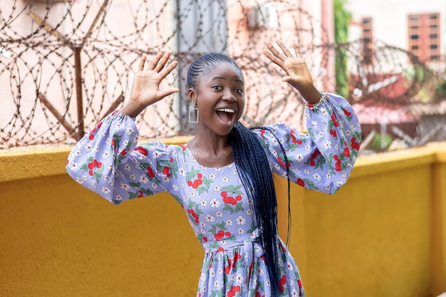 Foto de una alegre mujer africana levantando las manos emocionada