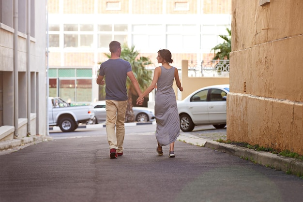 Foto amorosa urbana de um jovem casal caminhando ao ar livre