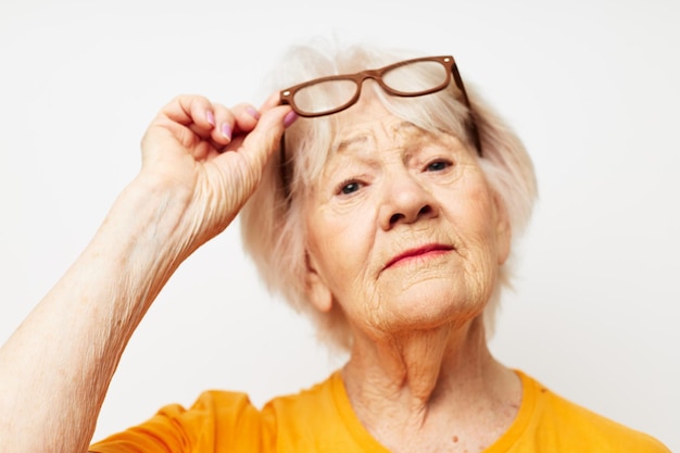 Foto de anciana jubilada en camiseta casual y anteojos de fondo aislado