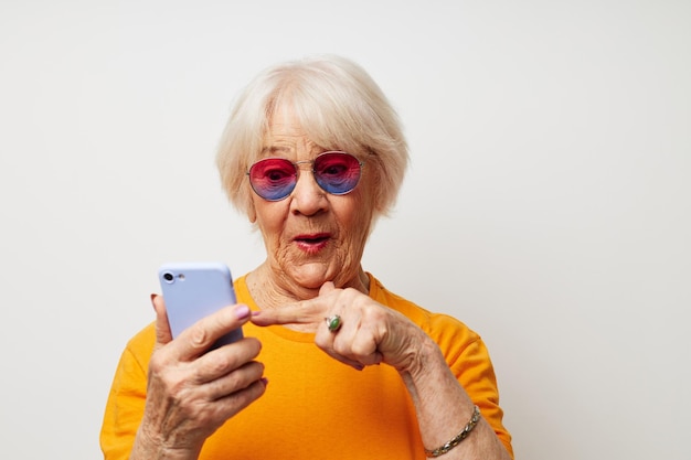 Foto de una anciana jubilada con gafas de sol informales hablando por teléfono vista recortada