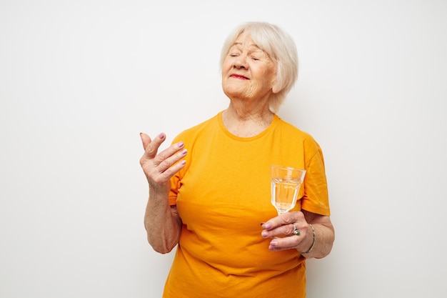 Foto de anciana jubilada sosteniendo un vaso de agua luz de fondo de salud