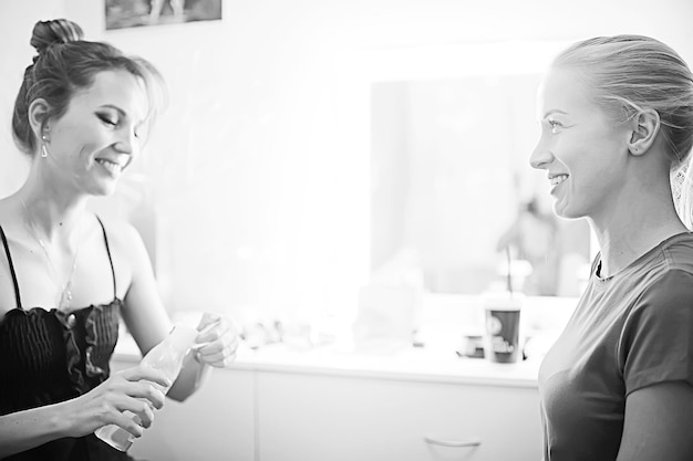 foto antigua en blanco y negro de una chica con maquillaje profesional / maquillaje estricto en la cara de una hermosa modelo profesional en un salón de belleza