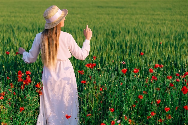 Foto ao ar livre de mulher jovem e bonita na garota do campo de papoulas