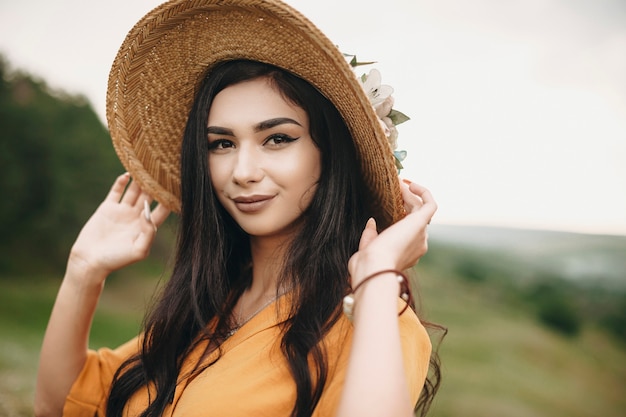 Foto ao ar livre de uma mulher atraente, olhando para a câmera. linda garota posando para a câmera ao ar livre em um campo sorrindo.