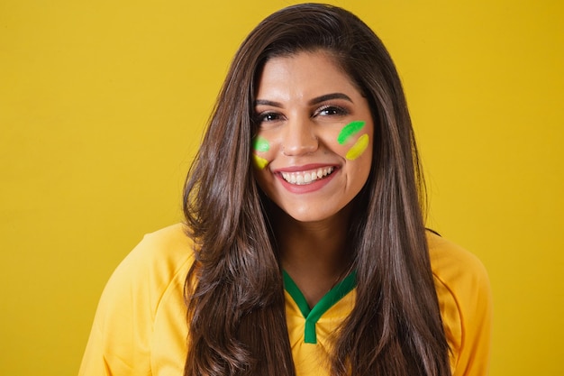 Foto aproximada da mulher torcedora do campeonato de futebol da copa do mundo 2022 do Brasil sorrindo