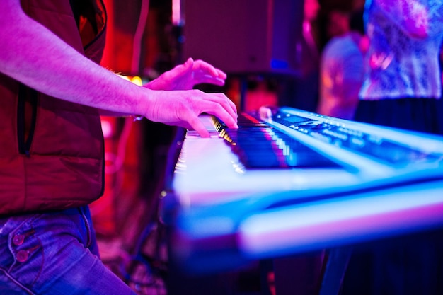 Foto aproximada das mãos do músico tocando o sintetizador na boate