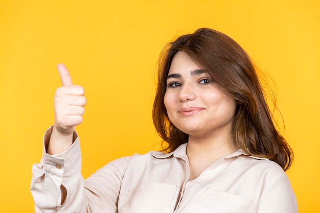 Foto aproximada de jovem gesticulando polegar para cima foto de alta qualidade