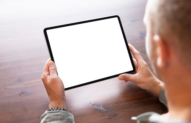 Foto aproximada de pessoa segurando maquete de tela vazia de tablet digital