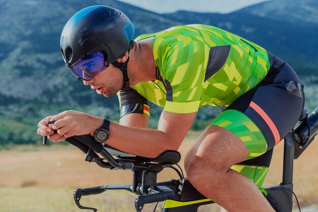 Foto foto aproximada de um triatleta ativo em roupas esportivas e com um capacete protetor andando de bicicleta. foco seletivo.