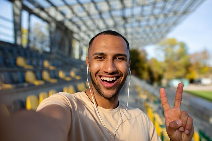 Foto foto aproximada jovem esportista afro-americano em fones de ouvido no estádio e tomando