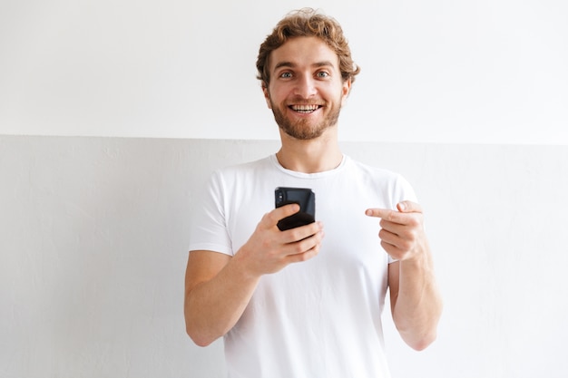 Foto de un apuesto joven en el interior de su casa mediante teléfono móvil.