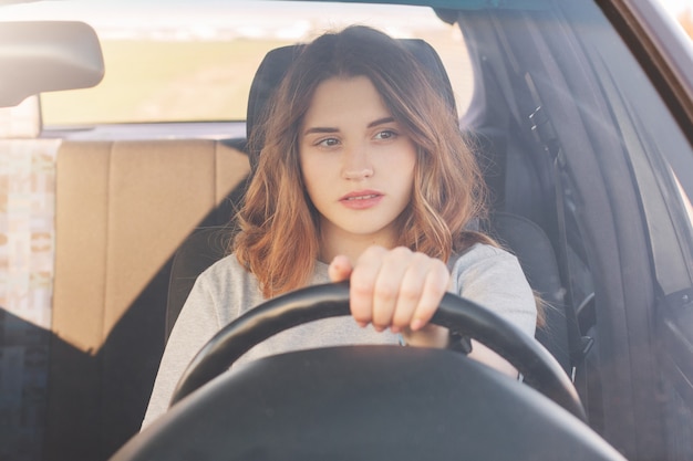 Foto de atractiva conductora se sienta en el coche