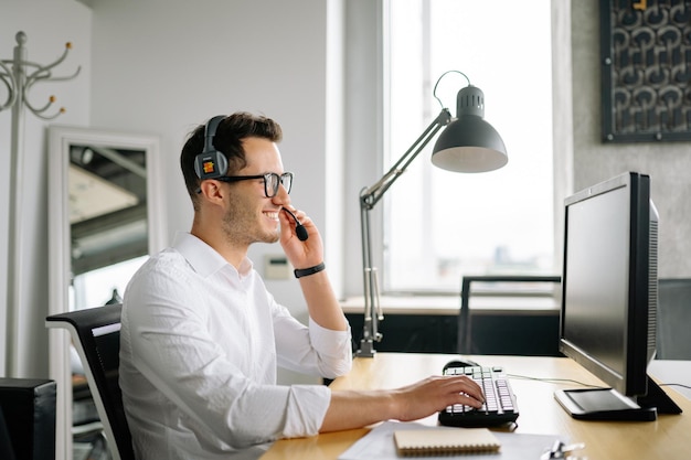 Foto con auriculares con micrófono trabajando en la oficina del centro de llamadas