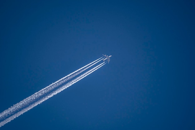 Foto foto de un avión con huellas de condensación.