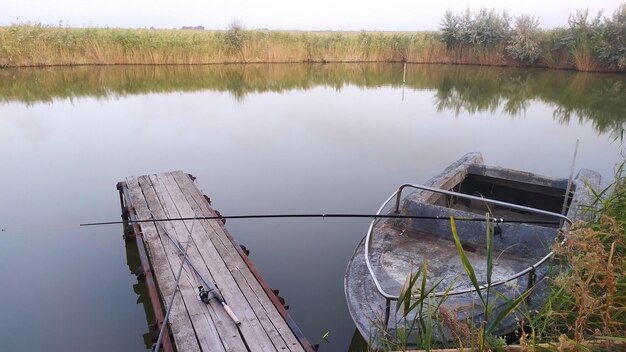 Foto del barco fluvial y del viejo puente pesquero El cielo y el campo se pueden ver a lo lejos