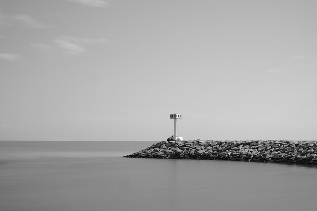 Una foto en blanco y negro de un faro con un cartel