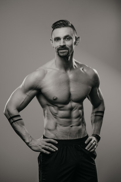 Una foto en blanco y negro de un hombre musculoso con barba que está posando