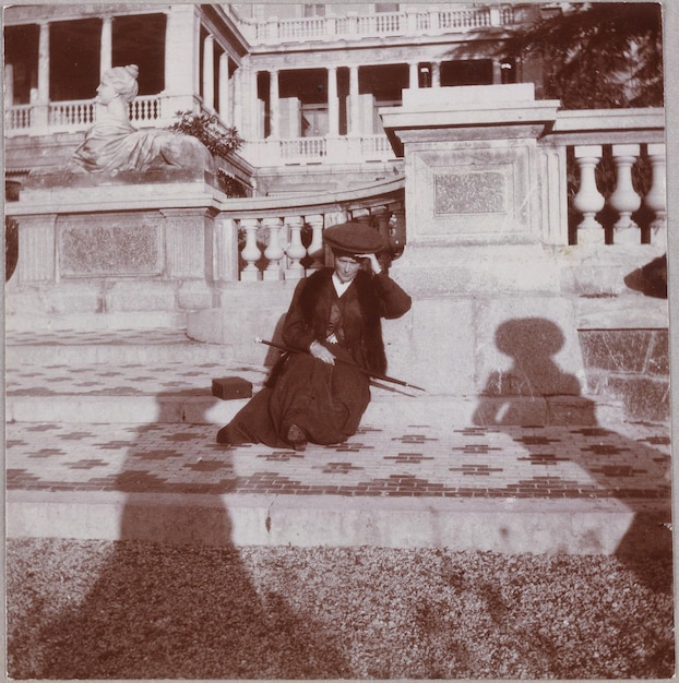 una foto en blanco y negro de un hombre sentado en una repisa de piedra