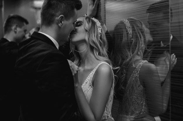 foto en blanco y negro. Primer plano de hombre y mujer, pareja joven besándose en ascensor.