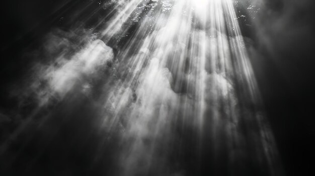 una foto en blanco y negro de los rayos del sol a través de las nubes