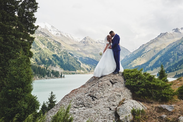 Foto de boda hermosa en el lago de montaña.