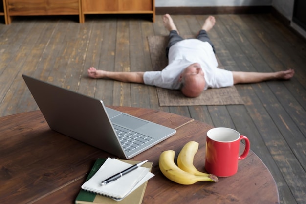 Foto borrada de homem caucasiano sênior deitado em pose de Shavasana