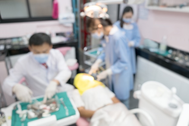 Foto borrosa de la imagen del dentista y su asistente están trabajando en la clínica.