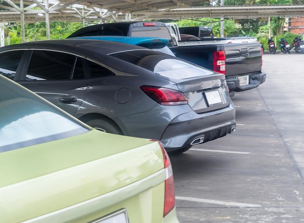 Foto foto borrosa imagen desenfocada camioneta y estacionamiento de automóviles ordenados en el estacionamiento de la tienda por departamentos estacionamiento de área abierta con techo parte trasera del automóvil