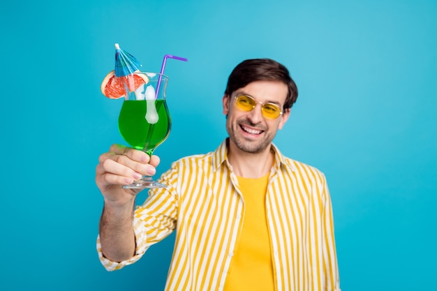 Foto borrosa de turista hombre alegre positivo disfrutar resort mirada escalofriante mantenga alcohol cóctel usar ropa blanca aislada sobre fondo de color azul