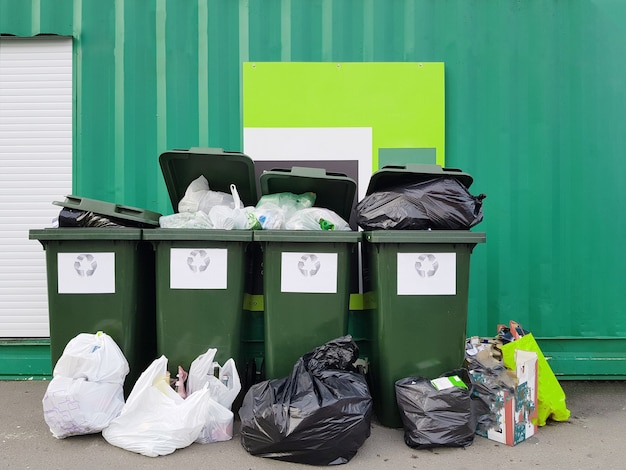 Foto de botes de basura bolsas de basura cerca de la valla verde