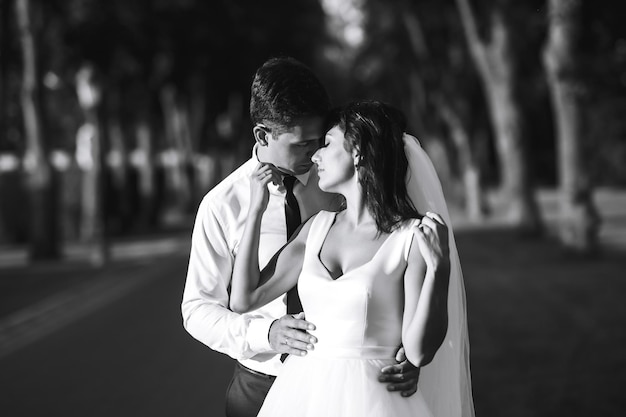 Foto branca e negra de recém-casados emocionais alegres que se divertem juntos Momento romântico