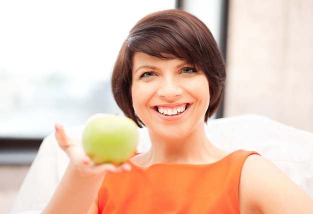 Foto foto brilhante de adorável dona de casa com maçã verde